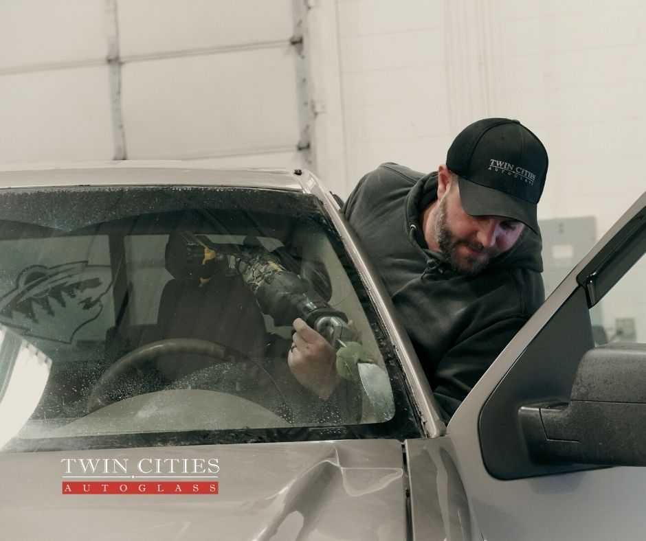 twin cities auto glass worker fixing auto glass